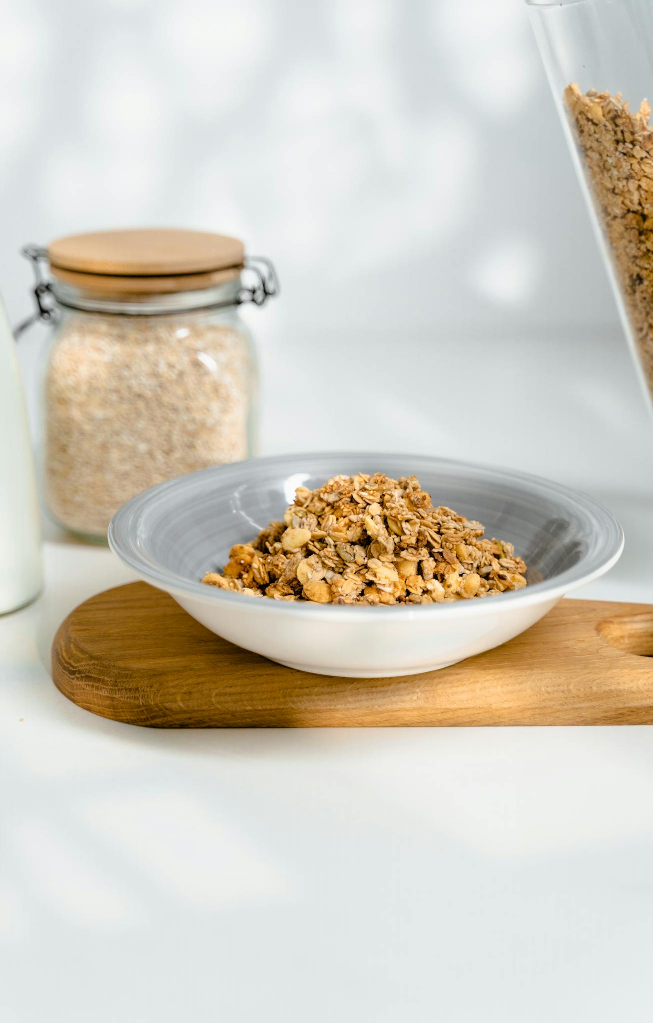 Bowl of nutritious muesli with oats and milk on a wooden board, perfect for a healthy start.