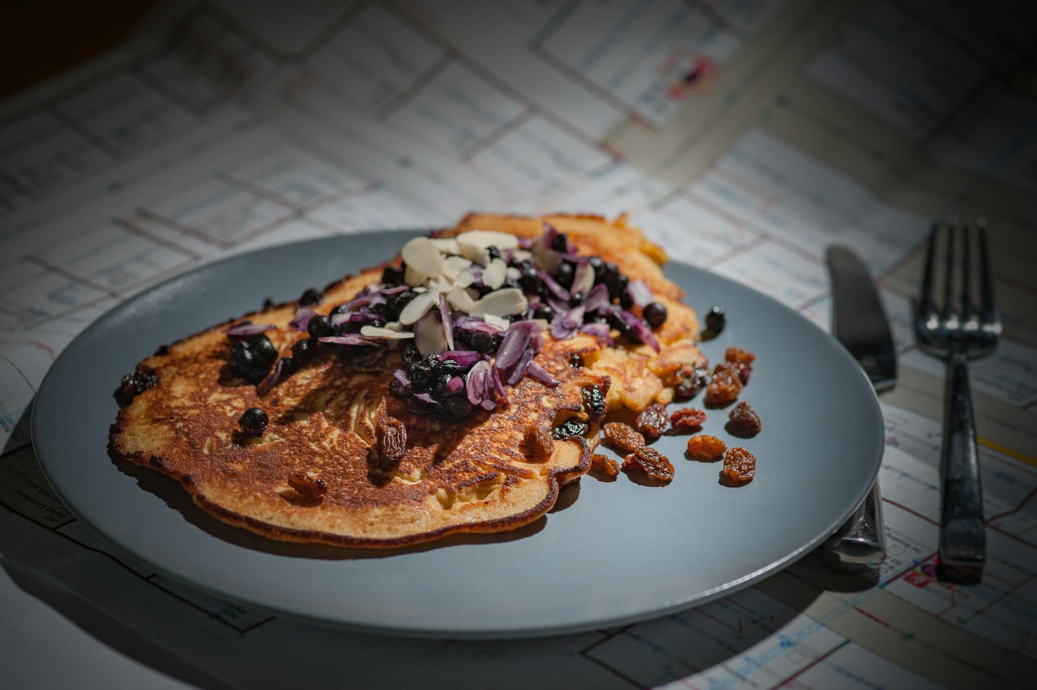 Tasty paleo pancake topped with almonds and raisins, ideal for healthy breakfasts.